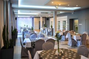 a banquet hall with tables and chairs with white tables at Hotel Duet in Chełm