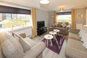a living room with a couch and a tv at Spacious 3 bedroom house in Stirling