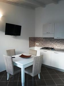 a white kitchen with a white table and chairs at Villa Lucia in Lampedusa