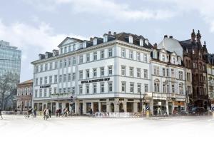 um grande edifício branco numa rua da cidade em Hotel Bayrischer Hof em Heidelberg