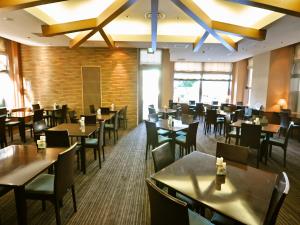 una sala da pranzo con tavoli e sedie in un ristorante di APA Hotel Obihiro Ekimae a Obihiro
