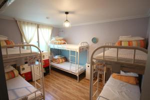 
a bed room with two bunk beds and a window at Yeha Guesthouse in Jeju
