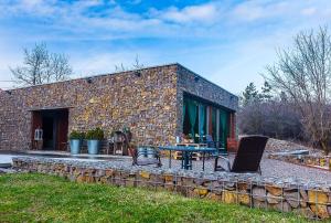 un bâtiment en briques avec une table et des chaises devant lui dans l'établissement Ezererdő Vendégház, à Egerbakta