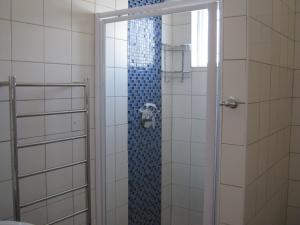 a shower in a bathroom with a glass door at Jetty Self-Catering in Swakopmund +114 photos