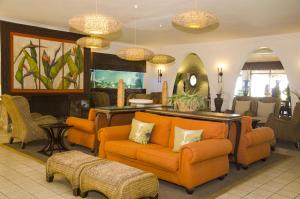 a living room with orange furniture and a fireplace at Salt Rock Hotel and Beach Resort in Ballito