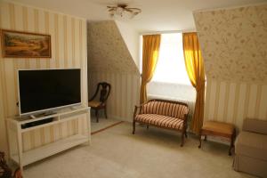 a living room with a television and a chair at Apartment Elena in Bad Wörishofen