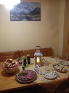 una mesa con platos de comida y una vela en ella en B&B Cascina Santa Gavi, en Gavi