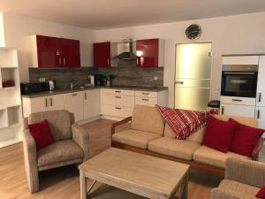 ein Wohnzimmer mit 2 Sofas und einer Küche in der Unterkunft ruhige Souterrainwohnung in Leverkusen