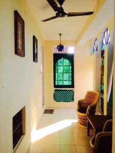 un couloir avec une chaise et une fenêtre dans l'établissement Blue King, à Jaipur
