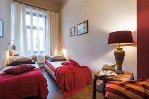 a room with two beds and a lamp on a table at Apartament Rynek Staromiejski in Toruń
