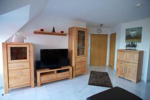 a living room with a flat screen tv and wooden cabinets at Neumann Apartment in Marbach am Neckar