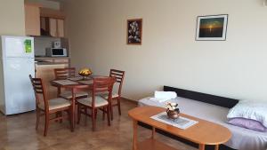 a living room with a dining room table and a kitchen at Tashevi Apartments in Pomorie