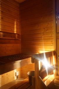 una sauna con una cama en una sala de madera en Wanha Pappila Cottages, en Simoniemi