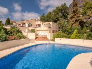 a villa with a swimming pool in front of a house at Villa near Montgó with Pool and Beach in Jávea