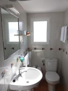 a bathroom with a sink and a toilet and a mirror at Hostal La Pilarica in Paterna +80 photos