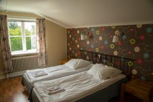 ein Schlafzimmer mit einem Bett mit Blumenwand in der Unterkunft B&B Kvarntorps Herrgård in Forshaga