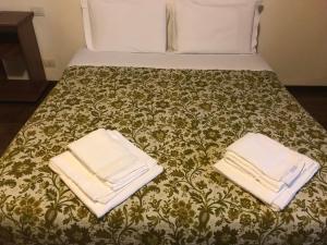 Una cama con dos toallas encima. en Le Magnolie Agriturismo en Verolanuova