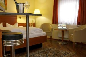 a hotel room with a bed and a table and chairs at Apartment Hotel KRAL - BUSINESS HOTEL & SERVICED APARTMENTS in Erlangen