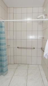 y baño con ducha de azulejos blancos. en Coral Palace Hotel, en Sangão
