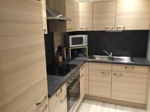 a kitchen with a sink and a microwave at Haus Heimo in Bad Kleinkirchheim