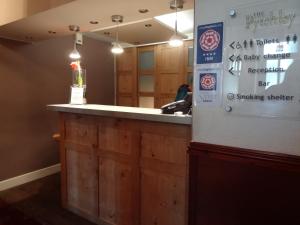 a bar in a restaurant with a mirror at The Pytchley Inn in West Haddon