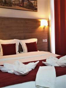Una habitación de hotel con una cama con toallas. en Hotel Luxor, en Issy-les-Moulineaux
