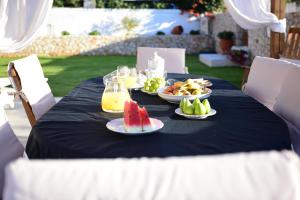 a table with plates of food and fruit on it at Stavros Beach Garden Villa in Stavros