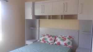 a bedroom with a bed with a pillow and white cabinets at Refugio na Serra 2 in Bananeiras
