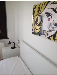 アルフェデーナにあるVilla Parco La Collinaのベッドルーム1室(ベッド1台付)が備わります。壁には絵画が飾られています。