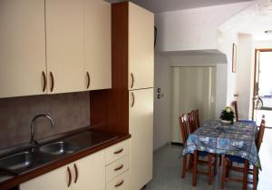 a kitchen with a sink and a table with chairs at S.Maria di Leuca - 30m mare - Salento(Le) in Leuca