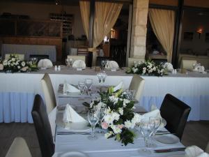 a dining room with tables with white and pink flowers at Hill View Hotel Apartments in Pissouri +37 photos