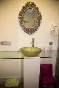 baño con encimera de cristal con lavabo y espejo en La Princesa y El Guisante, en Conil de la Frontera
