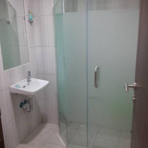 y baño con ducha acristalada y lavamanos. en Apartemen Ciumbuleuit 2, en Bandung