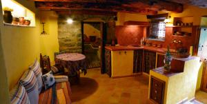 a kitchen with a counter and a table in a room at Casa Alba Ara in Oto