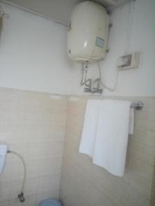 a bathroom with a towel dispenser and a toilet at Razhu Pru in Kohīma