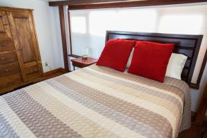 una camera da letto con un grande letto con cuscini rossi di Casa La Huerta ad Albuquerque