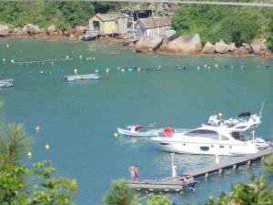 un barco está atracado en un muelle en el agua en Casa próxima a praia de Calheiros, en Governador Celso Ramos
