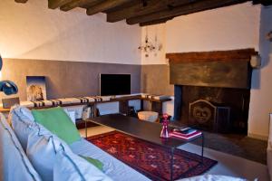 Maison Eth Bordac & Bordac Petit في Cazeaux-de-Larboust: غرفة معيشة مع أريكة ومدفأة