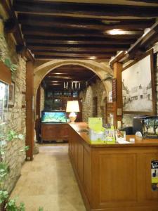 a bar in a room with a stone wall at Logis - Hôtel Restaurant l'Ecu de France in Malesherbes