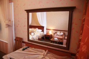 reflejo de un dormitorio en un espejo en Parad Park Hotel, en Tomsk
