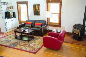 a living room with a couch and a chair and a stove at Casa La Huerta in Albuquerque