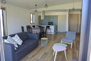a living room and kitchen with a couch and a table at Maison bord de mer avec jacuzzi in Névez