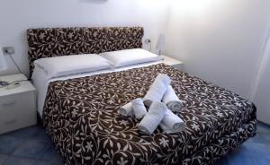 a bedroom with a bed with two rolled towels on it at Villa Lucia in Lampedusa