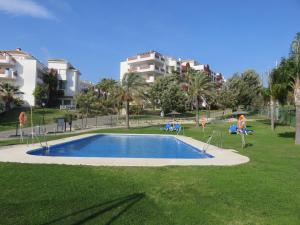 ein Schwimmbad in einem Park mit Gebäuden im Hintergrund in der Unterkunft Mijas - great apt in Mijas