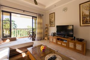 a living room with a couch and a tv at Belle Montagne Holiday Apartments in Grand'Anse