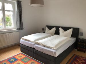 Schlafzimmer mit einem Bett mit weißer Bettwäsche und Kissen in der Unterkunft Ferienwohnungen in Dresden in Dresden