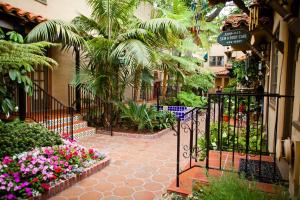 a courtyard with a gate with flowers and plants at El Cordova in San Diego