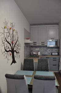 a kitchen with a table with chairs and a tree on the wall at Apartmán 14 Lúčky Demänovská dolina in Belá