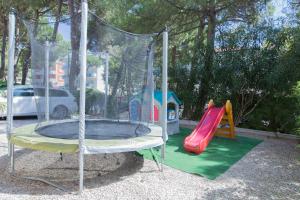 a playground with a trampoline and a slide at Hotel New York in Cervia