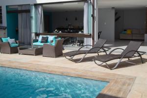 a group of chairs sitting next to a swimming pool at REF House Barra Da Tijuca in Rio de Janeiro